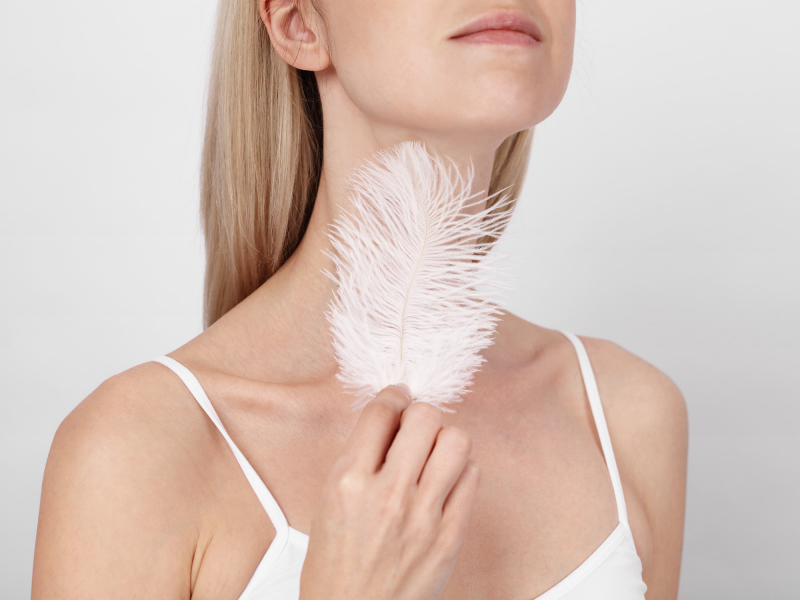 Une femme se caresse le cou avec une plume